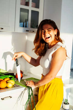 real cheerful lady on kitchen preparing dinner, lifestyle people conceptの写真素材