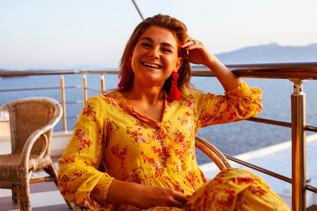 young pretty woman on balcony resting at sunset, lifestyle people concept