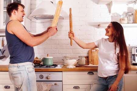 young caucasian couple together having fun on kitchen, woman pregnant, lifestyle people concept