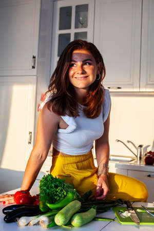 real cheerful lady on kitchen preparing dinner, lifestyle people conceptの写真素材
