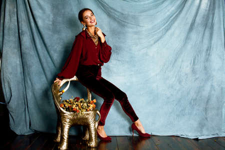 beauty rich brunette woman in luxury interior near empty frames, wearing fashion clothes, lifestyle people conceptの写真素材