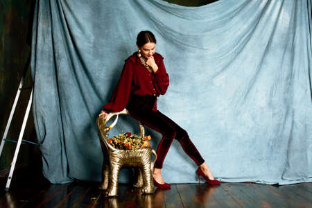 beauty rich brunette woman in luxury interior near empty frames, wearing fashion clothes, lifestyle people conceptの写真素材