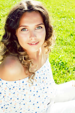 young cute summer girl on green grass outside relaxing smiling, lifestyle people conceptの写真素材