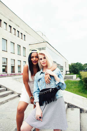 Two teenage diverse nations girls infront of university building smiling, having fun traveling europe, lifestyle people conceptの写真素材