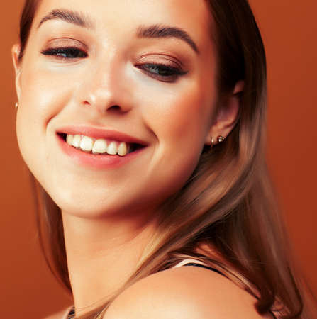 young pretty girl with blond hair posing cheerful on brown background, lifestyle people conceptの写真素材