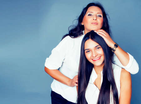 cute pretty teen daughter with mature mother hugging, fashion style brunette, lifestyle people conceptの写真素材