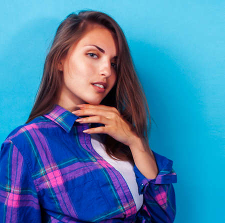 young pretty girl posing happy smiling on blue background, lifestyle people on summer vacation conceptの写真素材