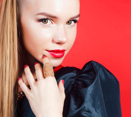 young pretty woman young lady posing on red background, lifestyle people conceptの写真素材
