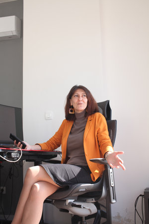 an adult woman in the office talking on phone callの写真素材