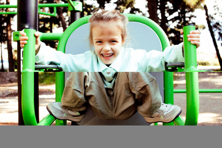 little cute girl with her mother and twin sister having fun on training playground outside