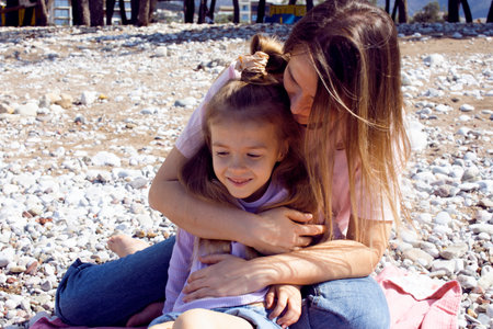 mother with twins daughters on beachの写真素材