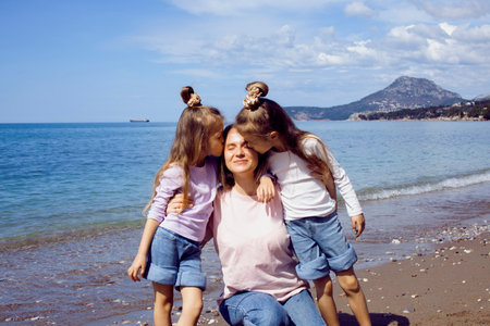 mother with twins daughters on beachの写真素材