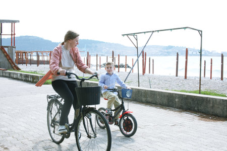 cute mother with children riding on bicycles on sea side, lifestyle peopleの写真素材