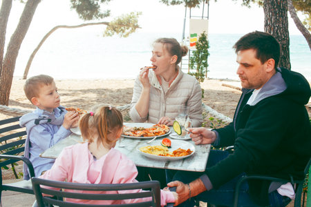 happy family eating pizza in cafe outside, lifestyle peopleの写真素材