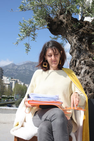 an adult woman on terrace making notes, working with phoneの写真素材