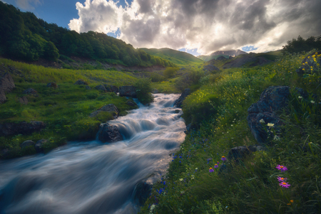 beautiful sunset over fast flowing mountain riverの写真素材