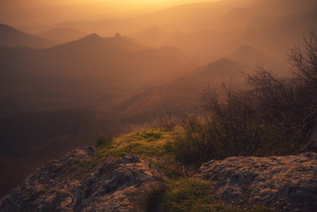 Colorful autumn sunset with sun rays coloring the hillsの写真素材