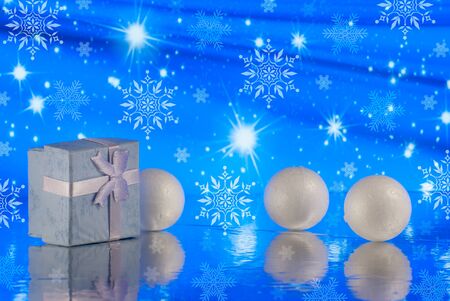 Christmas composition with gift or present box and decorative snowballs against holiday lights backgroundの写真素材