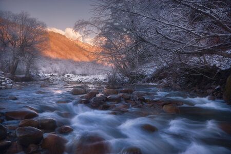 Beautiful rapid river flowing in the evening light, misty, winter season