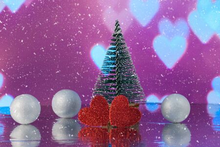 Christmas composition with Christmas tree, Hearts and decorative snowballs against holiday lights...