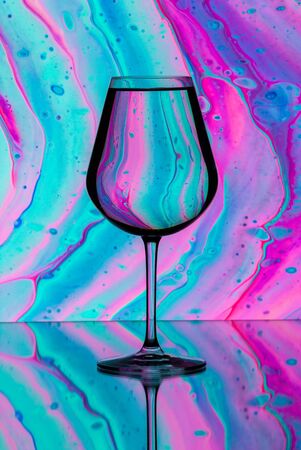 A glass of water faces a beautiful background