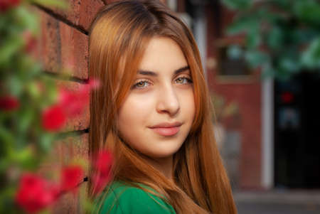 Cute teen girl posing in a city park at spring eveningの写真素材