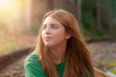 Young beautiful model posing on a railroad tracks