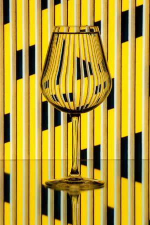 Glass of water against a striped background to illustrate the effect of water in refracting light. Still lifeの写真素材