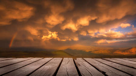The Sky With Clouds And A Rainbow After Rain with empty wooden table. Natural template landscape