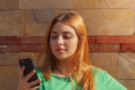 Close up portrait of a beautiful teenage girl with Phone posing in the city Street. Tbilisi. Georgiaの写真素材
