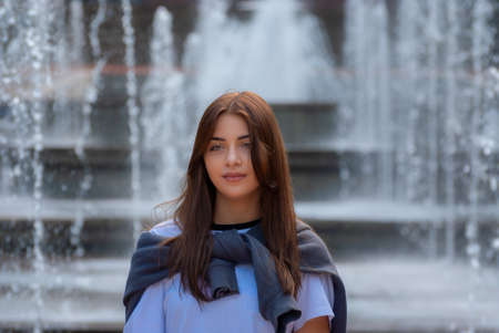 Cute teen girl posing in a city park at autumn evening.の写真素材