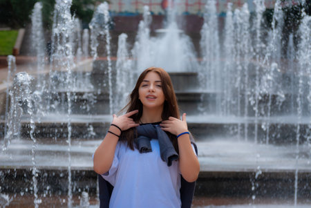 Cute teen girl posing in a city park at autumn evening.