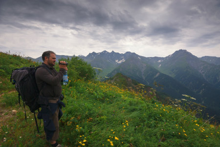 Georgia, Racha - August 16, 2013: The traveling man enjoys a magnificent view of the mountains.のeditorial素材