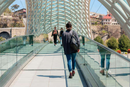 Georgia, Tbilisi - April 15, 2021: People walk on the Peace Bridge in Tbilisi.のeditorial素材