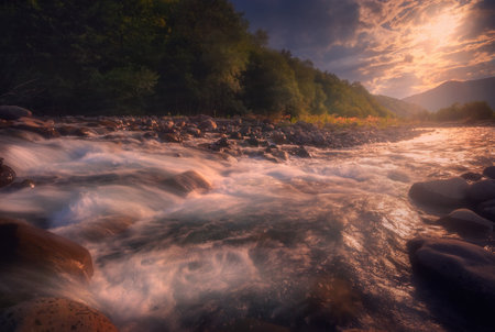 Beautiful sunset over fast flowing mountain river.