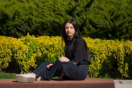 Cute teen girl posing in a city park at spring evening.