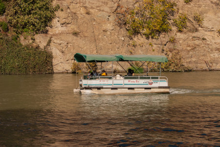 Georgia, Tbilisi - October 30, 2022: Tourists ride on a pleasure boat along the Mtkvari, Kura River.のeditorial素材
