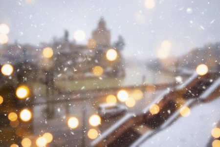 Beautiful winter blurred background of Tbilisi city with falling snow and bokeh lights.の写真素材