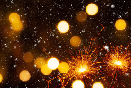 Burning sparklers on abstract snowy background, party concept.の写真素材