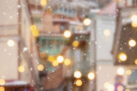 Beautiful winter blurred background of Tbilisi city with falling snow and bokeh lights.の写真素材