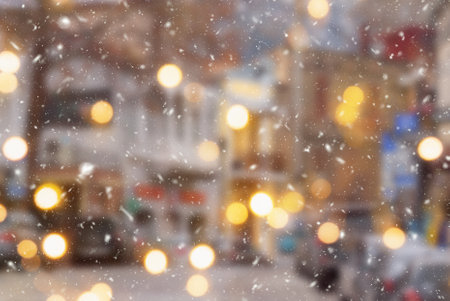 Beautiful winter blurred background of Tbilisi city with falling snow and bokeh lights.の写真素材