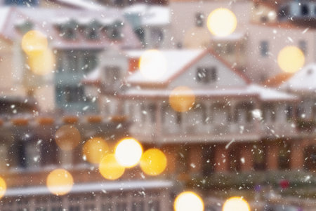 Beautiful winter blurred background of Tbilisi city with falling snow and bokeh lights.の写真素材