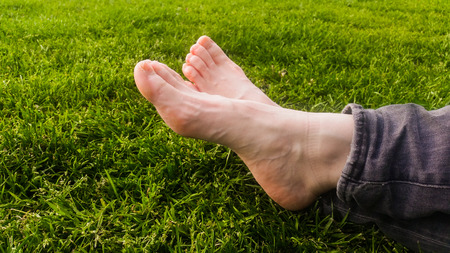 Barefoot on green grass under the sun light