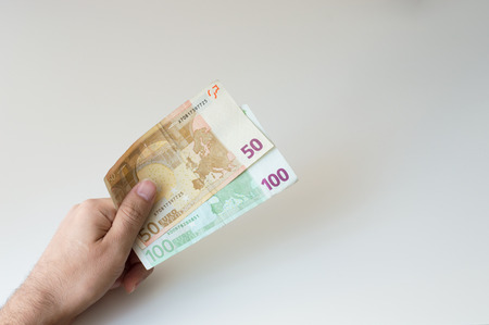 Man holding a hundred and fifty  Euro banknote in his handsの写真素材
