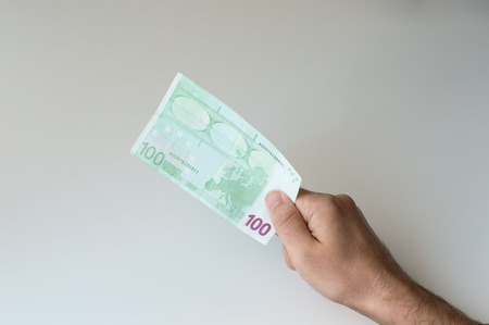 Man holding one hundred Euro banknote in his handsの写真素材