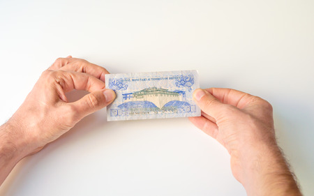 Man holding one Bhutanese Ngultrum banknote in his hands