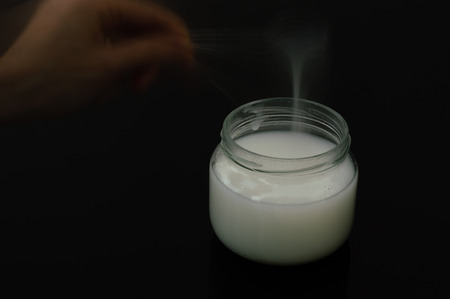 Ghost hand holding spoon over a jar of mastic gumの写真素材