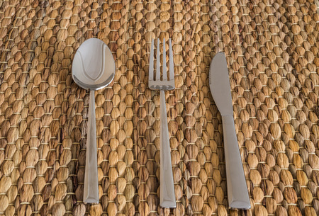 Cutlery set with fork, knife and spoon on a bamboo table mat
