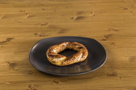 Traditional Turkish Pastry (Simit) served on a grey plate on a wooden table