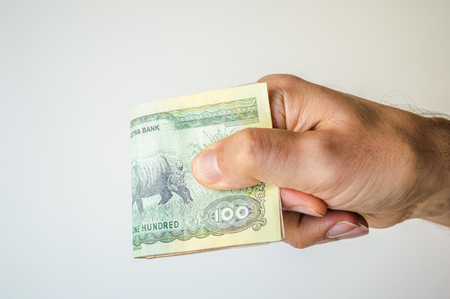Man holding Nepal Rupees banknotes in his hand